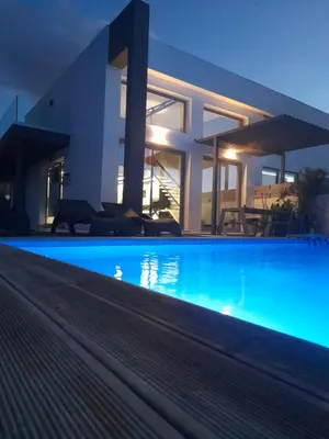 a swimming pool in front of a house at night at Casa di Rea Sanfilippo in Soroni