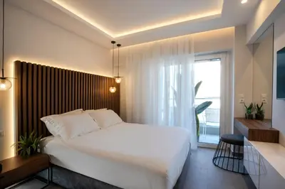 a bedroom with a large white bed and a window at Unique Central Lee Pham Apartment in Rhodes Town