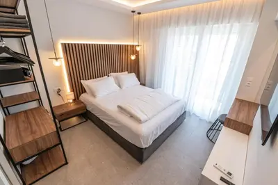 a bedroom with a bed with white sheets and a window at Unique Central Lee Pham Apartment in Rhodes Town