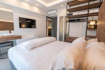 a bedroom with two beds and a room with a tv at Unique Central Lee Pham Apartment in Rhodes Town
