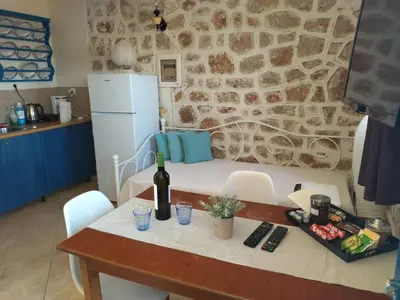 a kitchen with a table with a bottle of wine on it at Marina Castellana Studios II in Halki