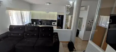 a living room with a black couch and a kitchen at Ixian House Apartment in Ixia