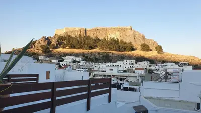 a view of a city with a mountain in the background at Toulipa Lindos in Líndos