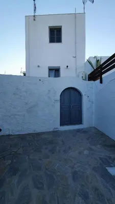 a white building with a door on the side of it at Toulipa Lindos in Líndos