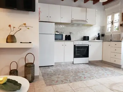 a kitchen with white cabinets and an oven and a table at SOFI'S house in Rhodes Town