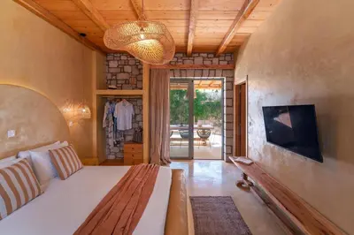 a living room with a bed and a television and a couch at Eftopia Villa Kolympia by Onar Villas in Kolimbia
