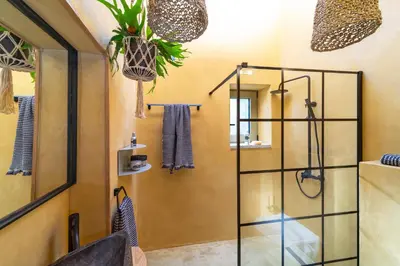 a bathroom with a shower with a glass door at Eftopia Villa Kolympia by Onar Villas in Kolimbia