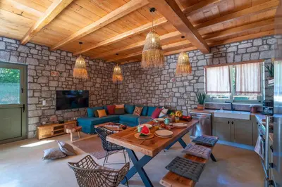 a living room with a table and a blue couch at Eftopia Villa Kolympia by Onar Villas in Kolimbia