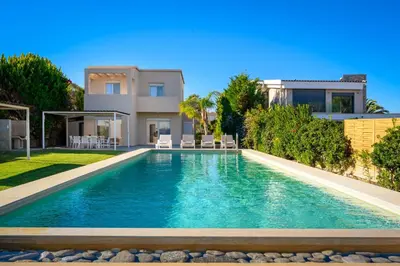 a villa with a swimming pool in front of a house at Sea Homes Villas- Villa Alberto in Kiotari