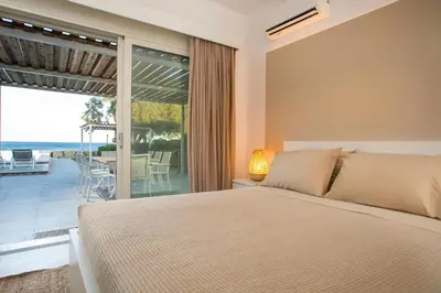 a bedroom with a bed and a view of the ocean at Sea Homes Villas- Villa Alberto in Kiotari