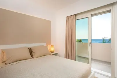 a bedroom with a bed and a view of the ocean at Sea Homes Villas- Villa Alberto in Kiotari