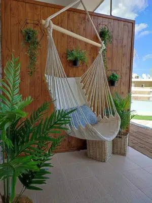 a hammock hanging from a wooden fence with potted plants at Peace & View in Archangelos