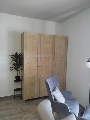 a living room with a chair and a cabinet at Peace & View in Archangelos
