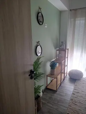 a room with two clocks on the wall and a plant at Peace & View in Archangelos