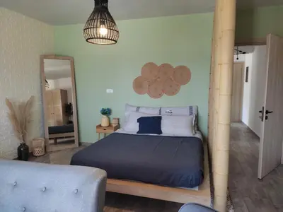 a bedroom with a bed with a blue comforter and a mirror at Peace & View in Archangelos