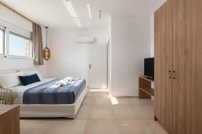 a bedroom with a bed and a television in it at Ossiano Pool Villas,Heating Pool, 2 min drive to Haraki Beach & 10 min to Lindos in Haraki
