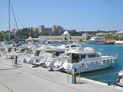 a bunch of boats are docked in a harbor at Ossiano Pool Villas,Heating Pool, 2 min drive to Haraki Beach & 10 min to Lindos in Haraki