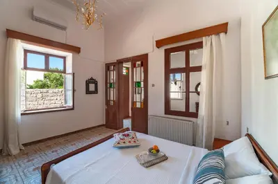 a bedroom with a bed and a couch and windows at Traditional 3 bedroom house in the Old Town in Rhodes Town