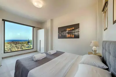 a bedroom with a bed and a large window at Villa Angelina Olivestone by Villa Plus in Yennadhion