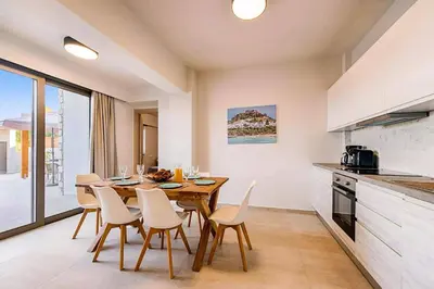 a kitchen and dining room with a table and chairs at Villa Angelina Olivestone by Villa Plus in Yennadhion