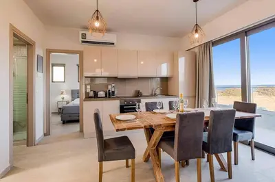 a kitchen and dining room with a table and chairs at Villa Angelina Olivestone by Villa Plus in Yennadhion