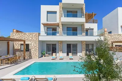 a villa with a swimming pool in front of a building at Villa Angelina Olivestone by Villa Plus in Yennadhion