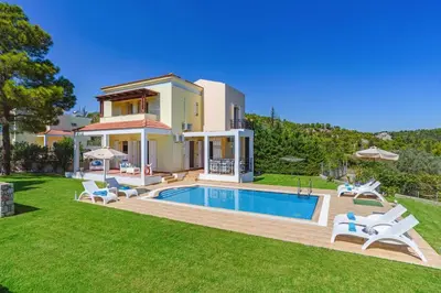 a villa with a swimming pool in a yard at Villa Ermis Springs by Villa Plus in Kolimbia