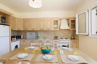 a kitchen with a table with a bowl of fruit on it at Villa Ermis Springs by Villa Plus in Kolimbia