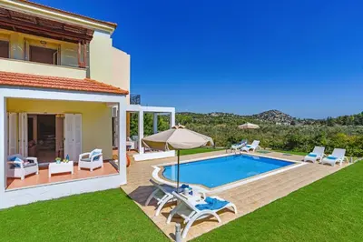 a villa with a swimming pool and a house at Villa Ermis Springs by Villa Plus in Kolimbia