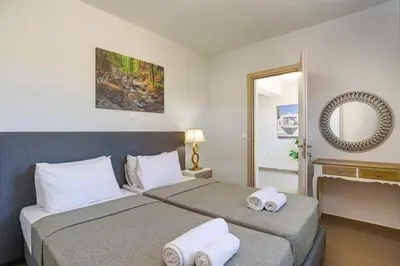 a bedroom with two beds and a mirror at Villa Eva Olivestone by Villa Plus in Yennadhion