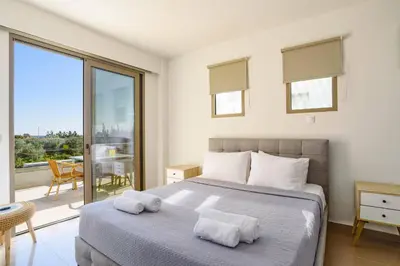 a bedroom with a bed with two towels on it at Villa Eva Olivestone by Villa Plus in Yennadhion