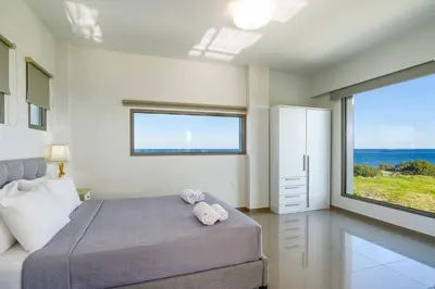 a bedroom with a bed and a large window at Villa Eva Olivestone by Villa Plus in Yennadhion
