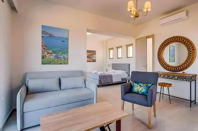 a living room with a couch and a bed at Villa Nikos Olivestone by Villa Plus in Yennadhion