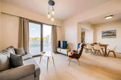 a living room with a couch and a table at Villa Nikos Olivestone by Villa Plus in Yennadhion