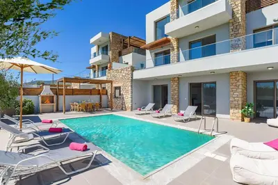 a villa with a swimming pool and patio furniture at Villa Nikos Olivestone by Villa Plus in Yennadhion