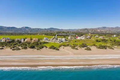 an aerial view of a resort on a beach at Villa Nikos Olivestone by Villa Plus in Yennadhion
