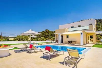a villa with a swimming pool and a house at Villa Paleos Aegean by Villa Plus in Ialyssos