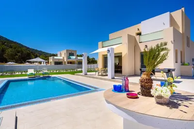 a villa with a swimming pool in front of a building at Villa Paleos Evergreen by Villa Plus in Ialyssos