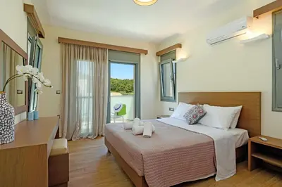 a hotel room with a bed and a large window at Villa Paleos Evergreen by Villa Plus in Ialyssos