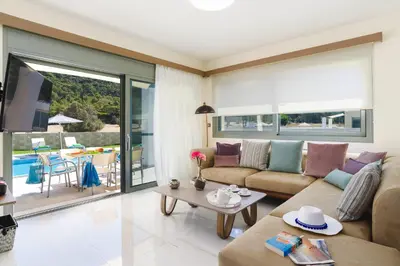 a living room with a couch and a table at Villa Paleos Evergreen by Villa Plus in Ialyssos