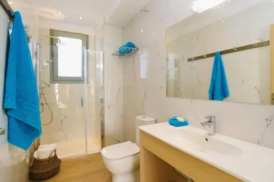 a bathroom with a sink and a toilet and a shower at Villa Paleos Evergreen by Villa Plus in Ialyssos