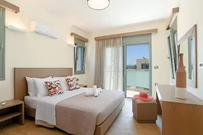 a bedroom with a bed and a large window at Villa Paleos Hillside by Villa Plus in Ialyssos