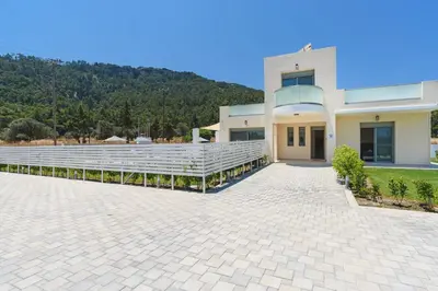 a large building with white bleachers in front of it at Villa Paleos Hillside by Villa Plus in Ialyssos