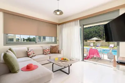 a living room with a couch and a table at Villa Paleos Hillside by Villa Plus in Ialyssos