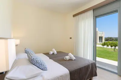a bedroom with a bed with two stuffed animals on it at Villa Paleos Hillside by Villa Plus in Ialyssos