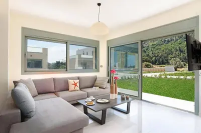 a living room with a couch and a table at Villa Paleos Sunset by Villa Plus in Ialyssos