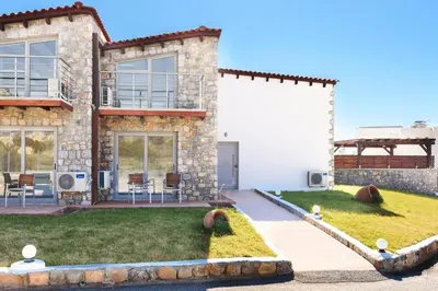 a house with a lawn in front of it at Villa Alcyone Seastone by Villa Plus in Kiotari