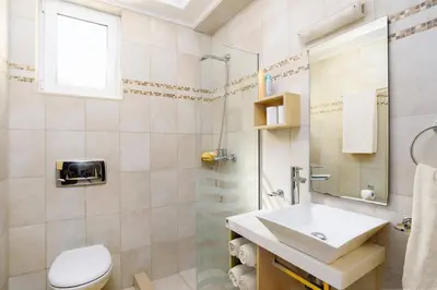 a bathroom with a sink and a toilet and a shower at Villa Alexia by Villa Plus in Pefki Rhodes