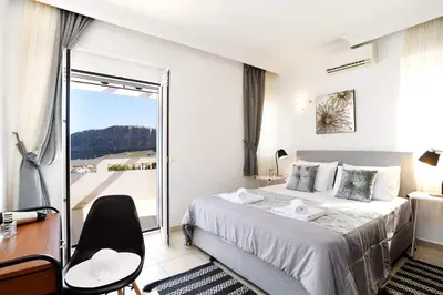 a hotel room with a bed and a balcony at Villa Alexia by Villa Plus in Pefki Rhodes
