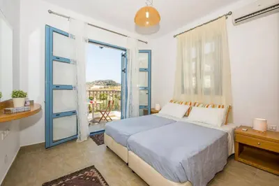 a bedroom with a bed and a large window at Villa Aqua Blu by Villa Plus in Líndos